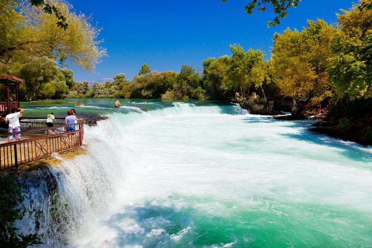 un gruppo di persone in piedi su un ponte sopra una cascata
