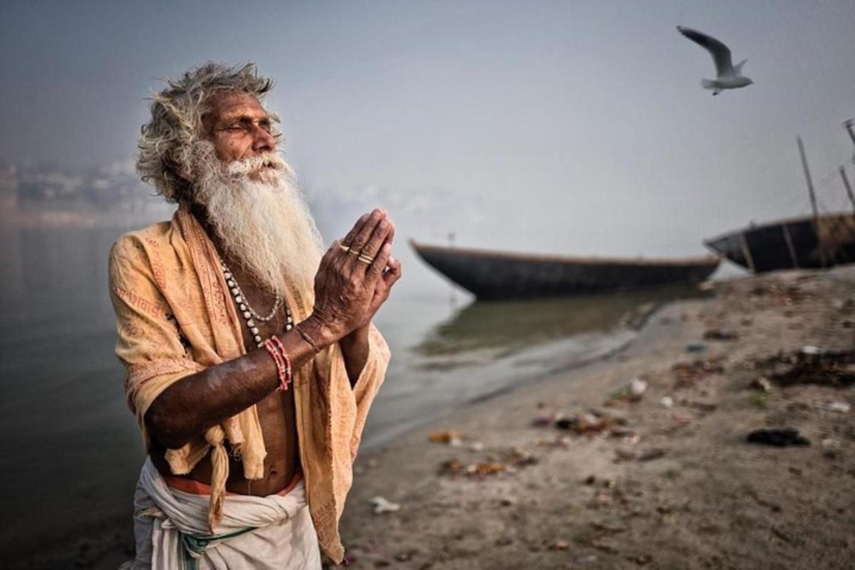 a man with a long beard standing next to the water