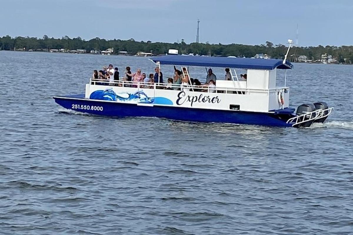 Skupina lidí na modrobílé lodi na vodě