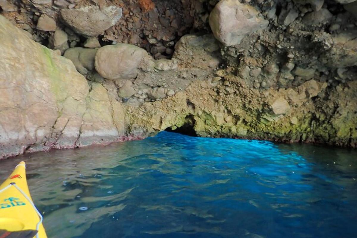 un kayak in una grotta con acqua blu