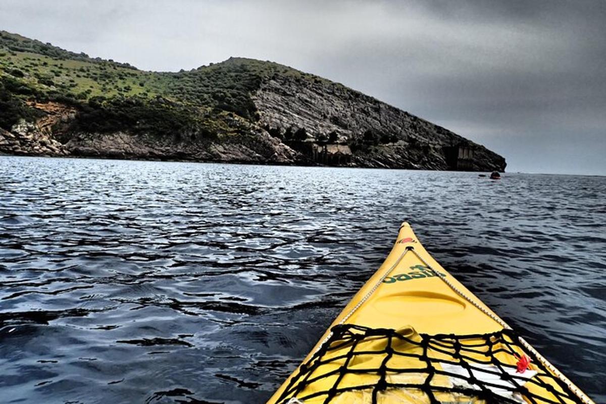 un kayak giallo nell'acqua vicino a una montagna