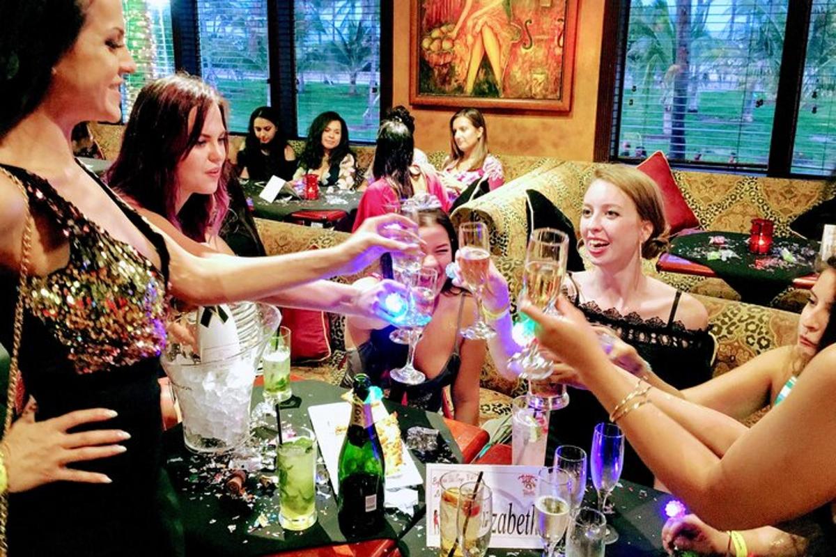 eine Gruppe von Frauen sitzt mit Weingläsern um einen Tisch