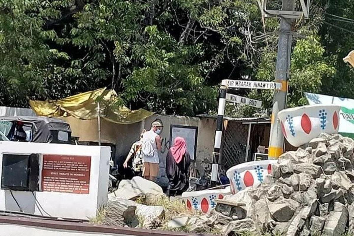 a man standing next to a pile of rocks