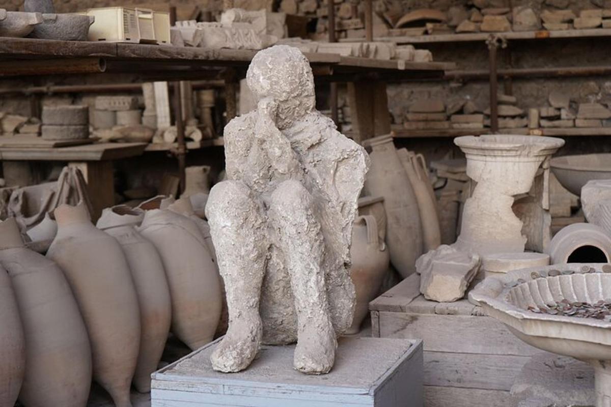 uma estátua de uma pessoa sentada em frente a vasos