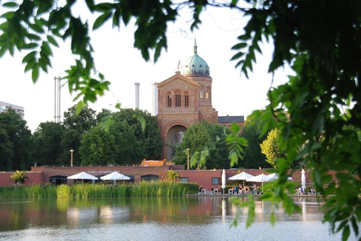 un edificio con una torre dell'orologio di fronte a uno specchio d'acqua