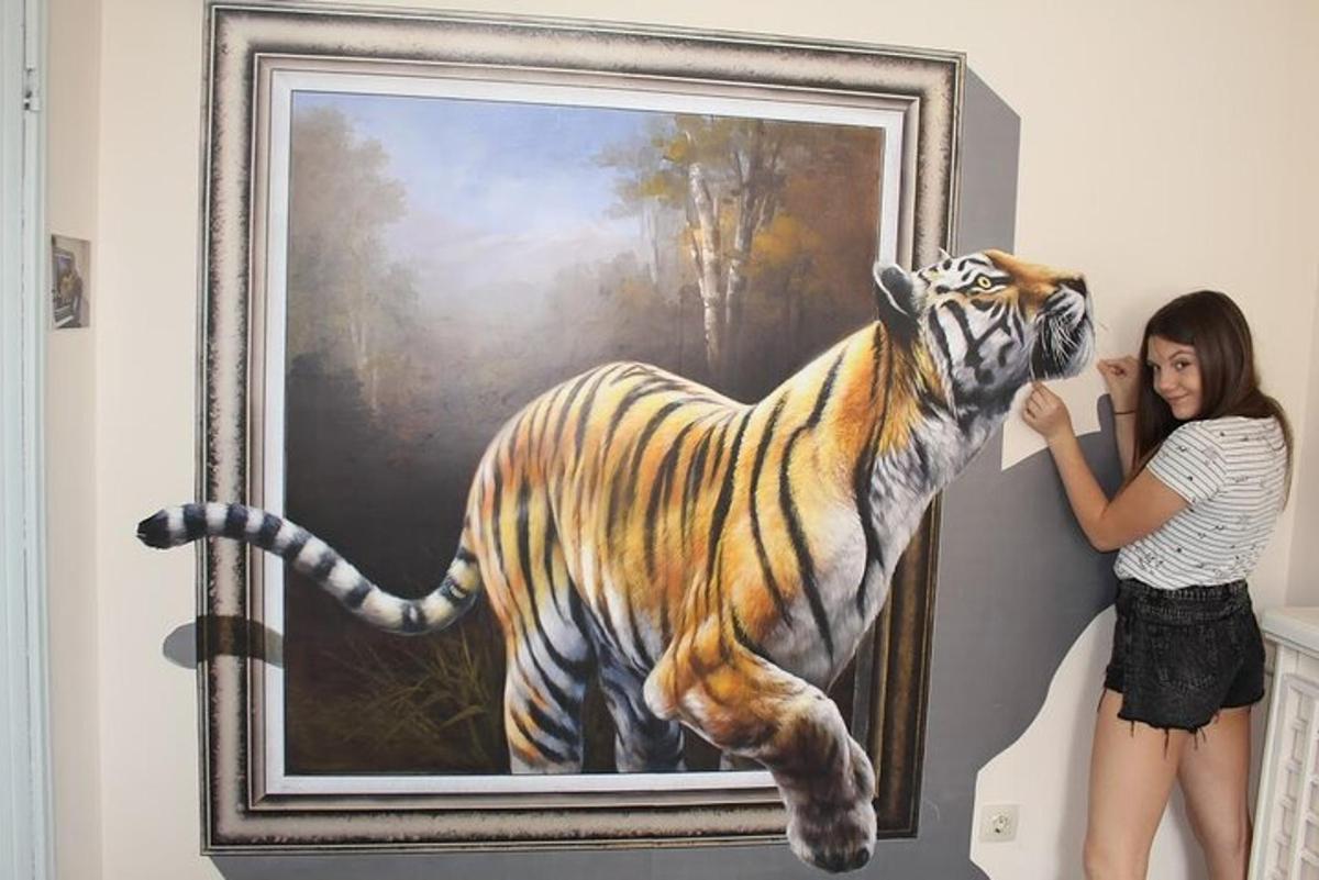 a woman standing next to a painting of a tiger