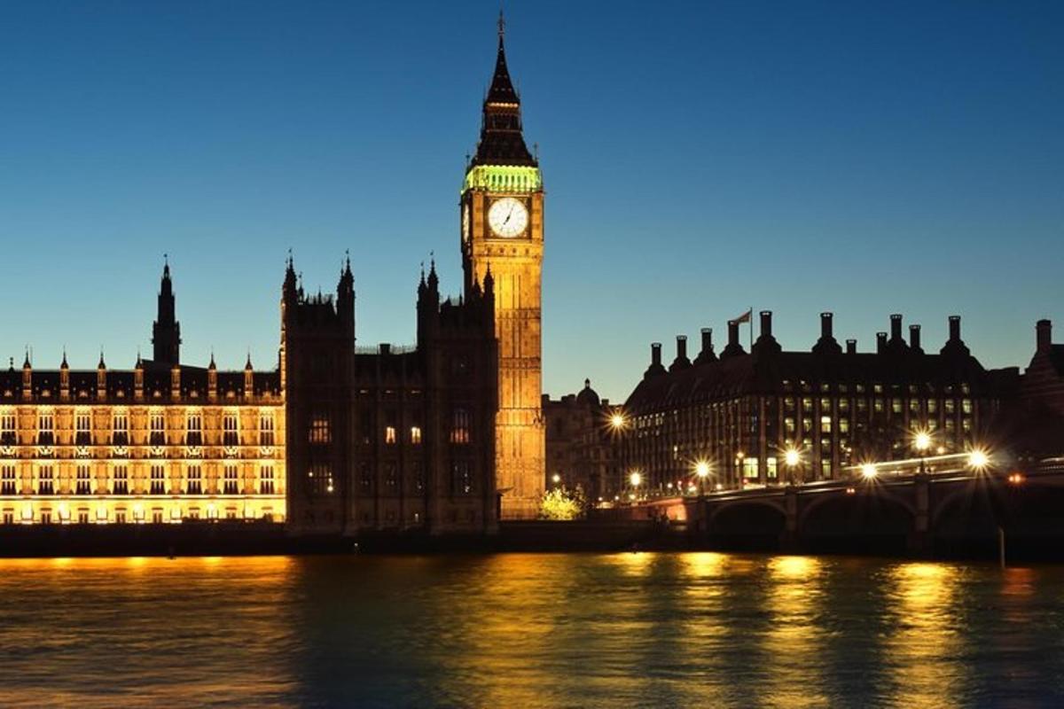 un edificio con una torre dell'orologio e il Big Ben di notte