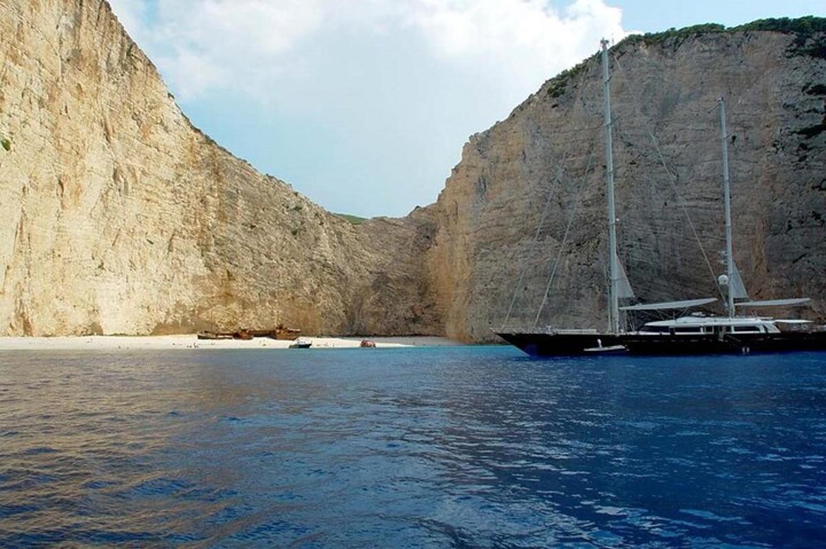 una barca seduta sull'acqua accanto a una scogliera