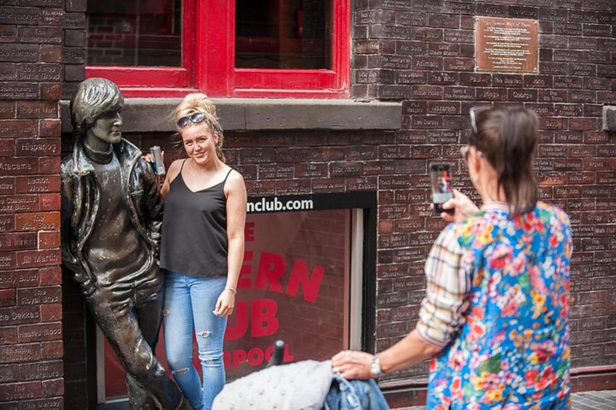 a woman standing next to a statue of a man