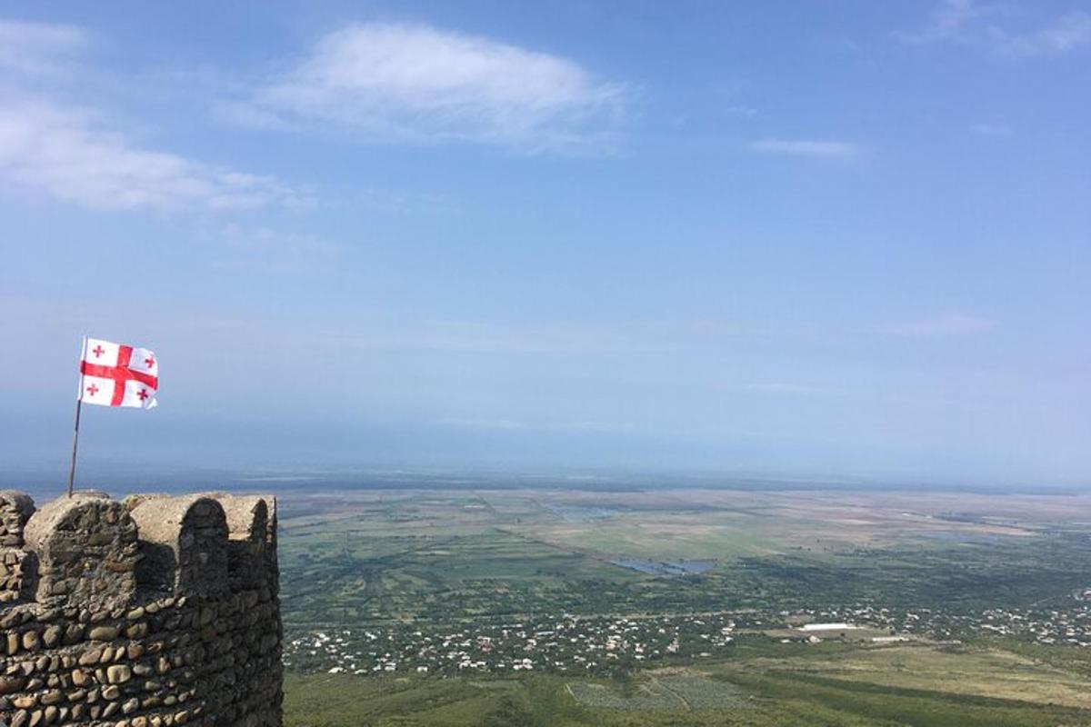 uma bandeira no topo de um castelo com uma cidade