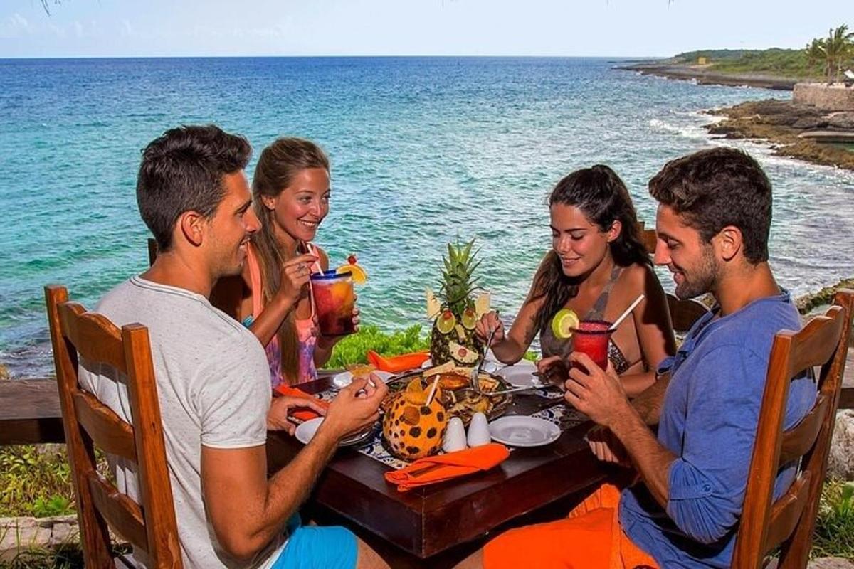 a group of people sitting around a table by the ocean