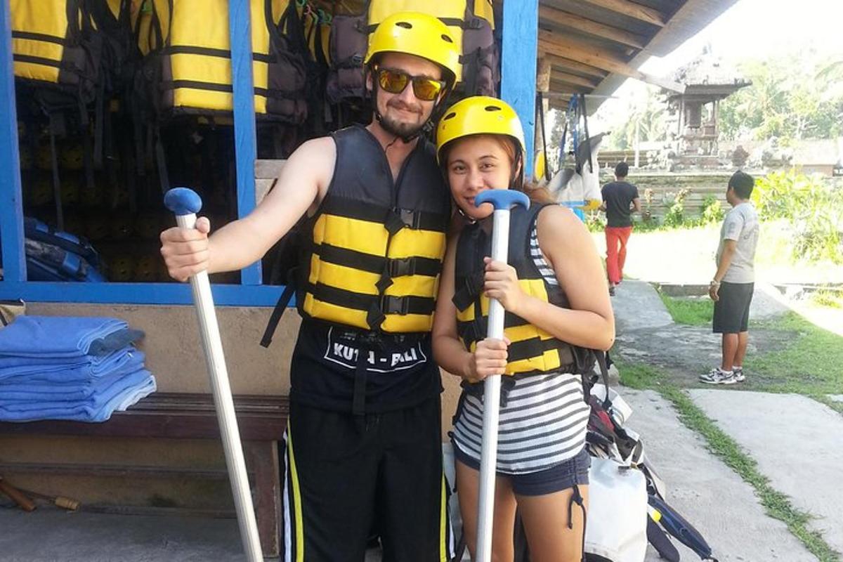 a man and a woman dressed in life jackets and holding poles