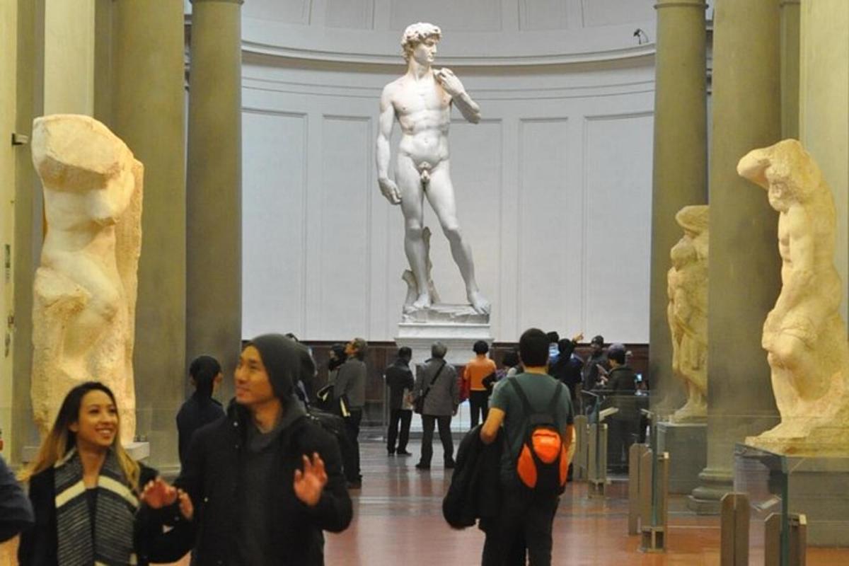 persone che camminano in un museo con una statua sullo sfondo