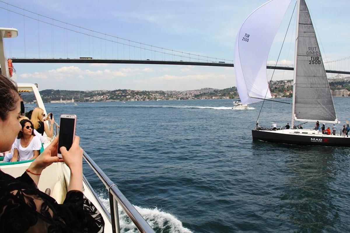una persona che scatta una foto di una barca a vela e di una barca