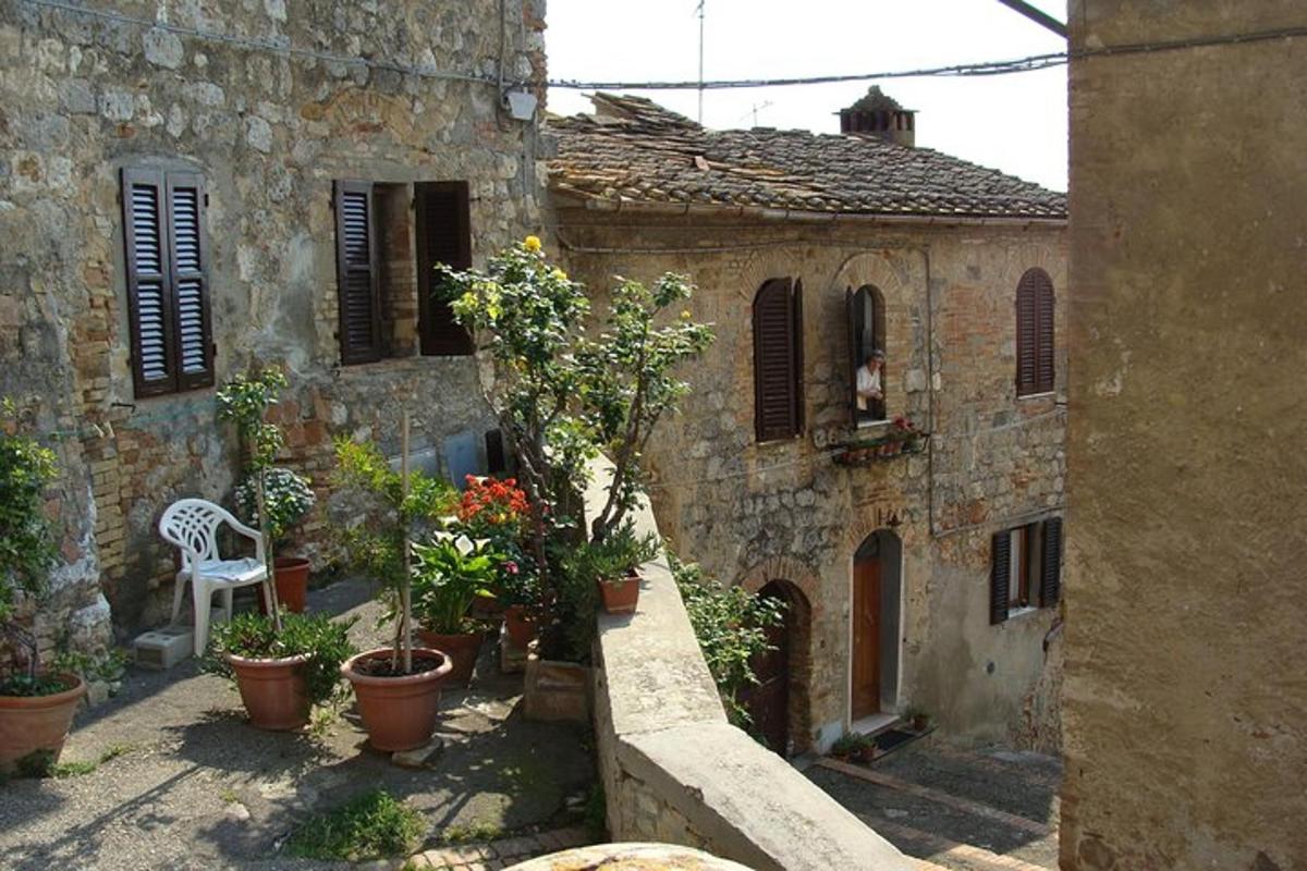 an old stone building with potted plants and a chair