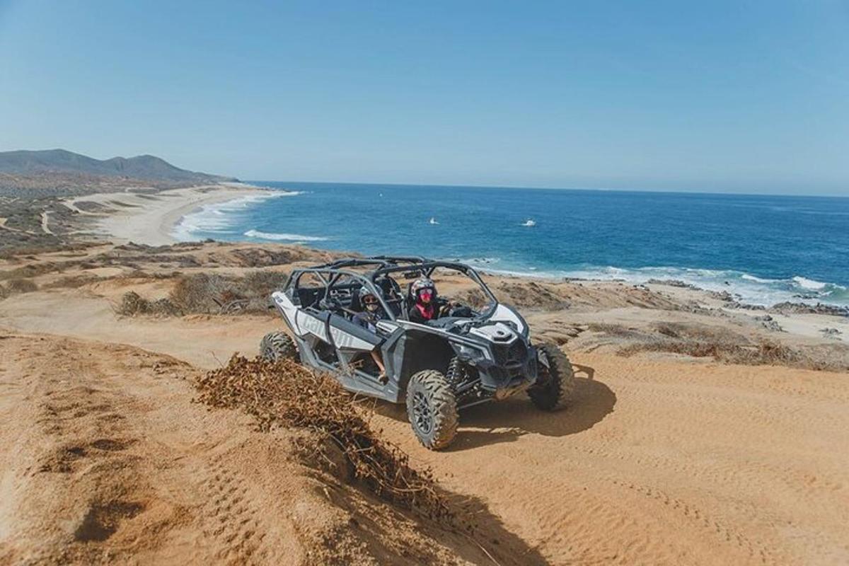 o persoană într-un ATV care conduce pe o plajă
