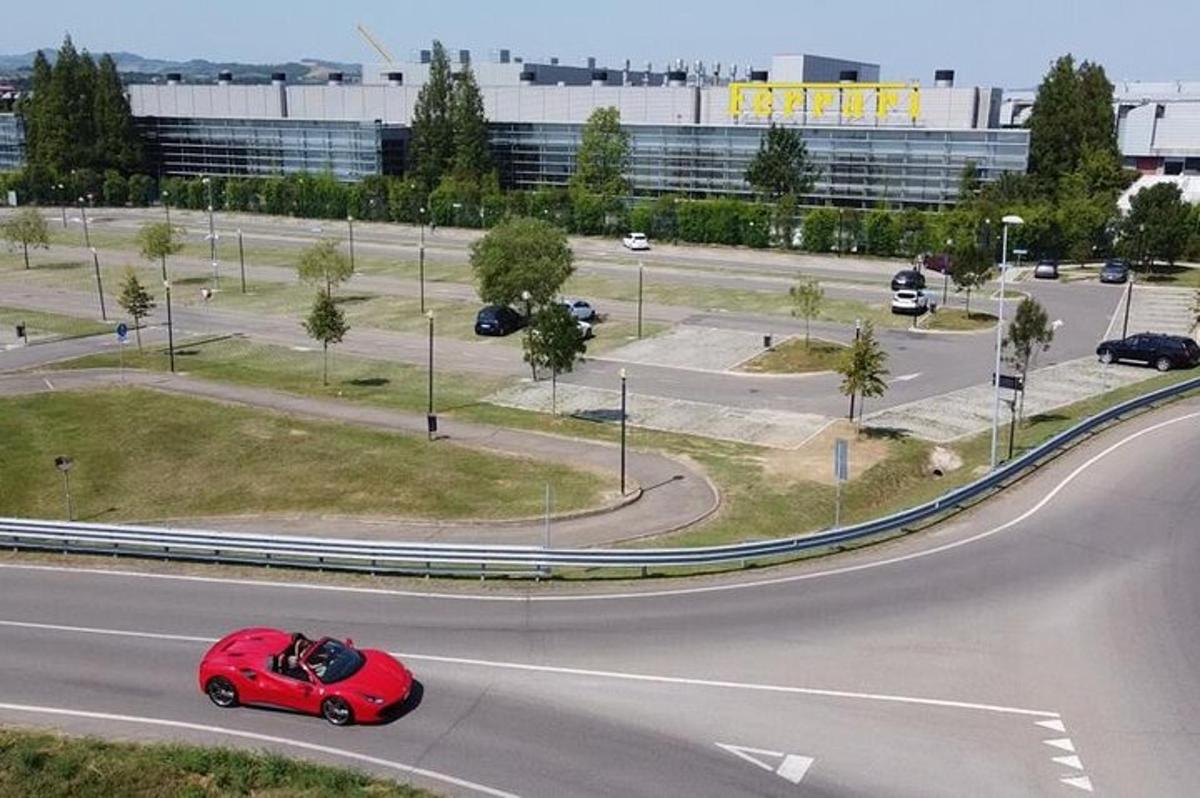 a red car is driving down a road