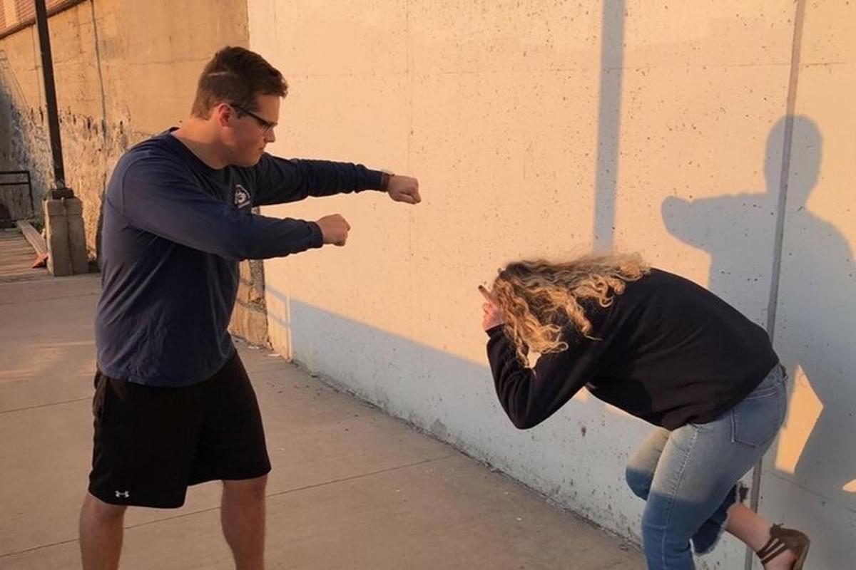 um homem e uma mulher em pé perto de uma parede