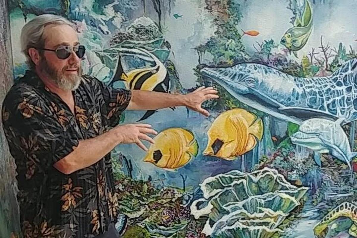 a man standing in front of a painting of a fish