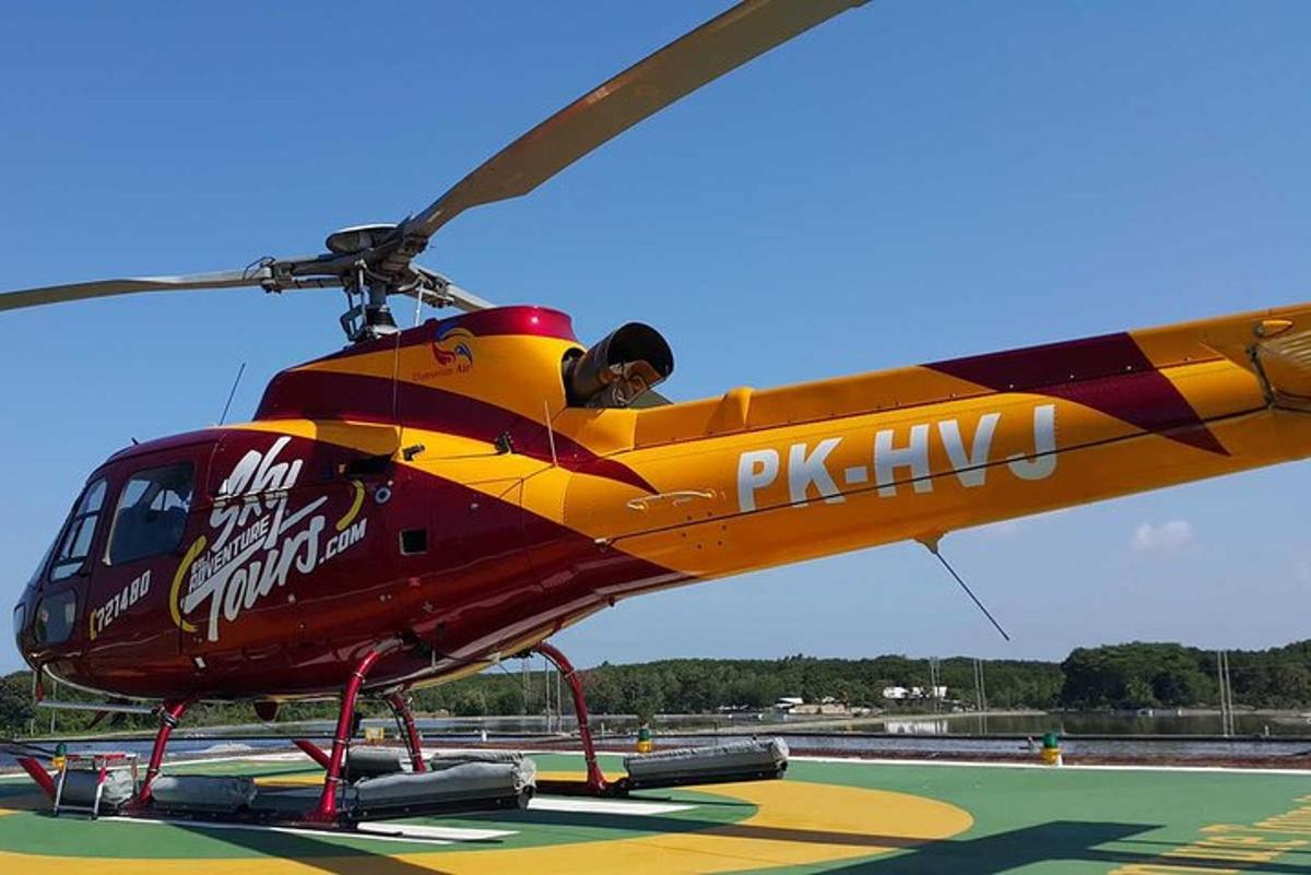 rdeče-rumeni helikopter, parkiran na vzletno-pristajalni stezi