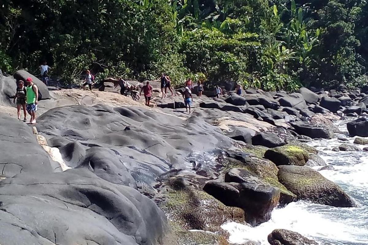 a group of people walking on the rocks near a river