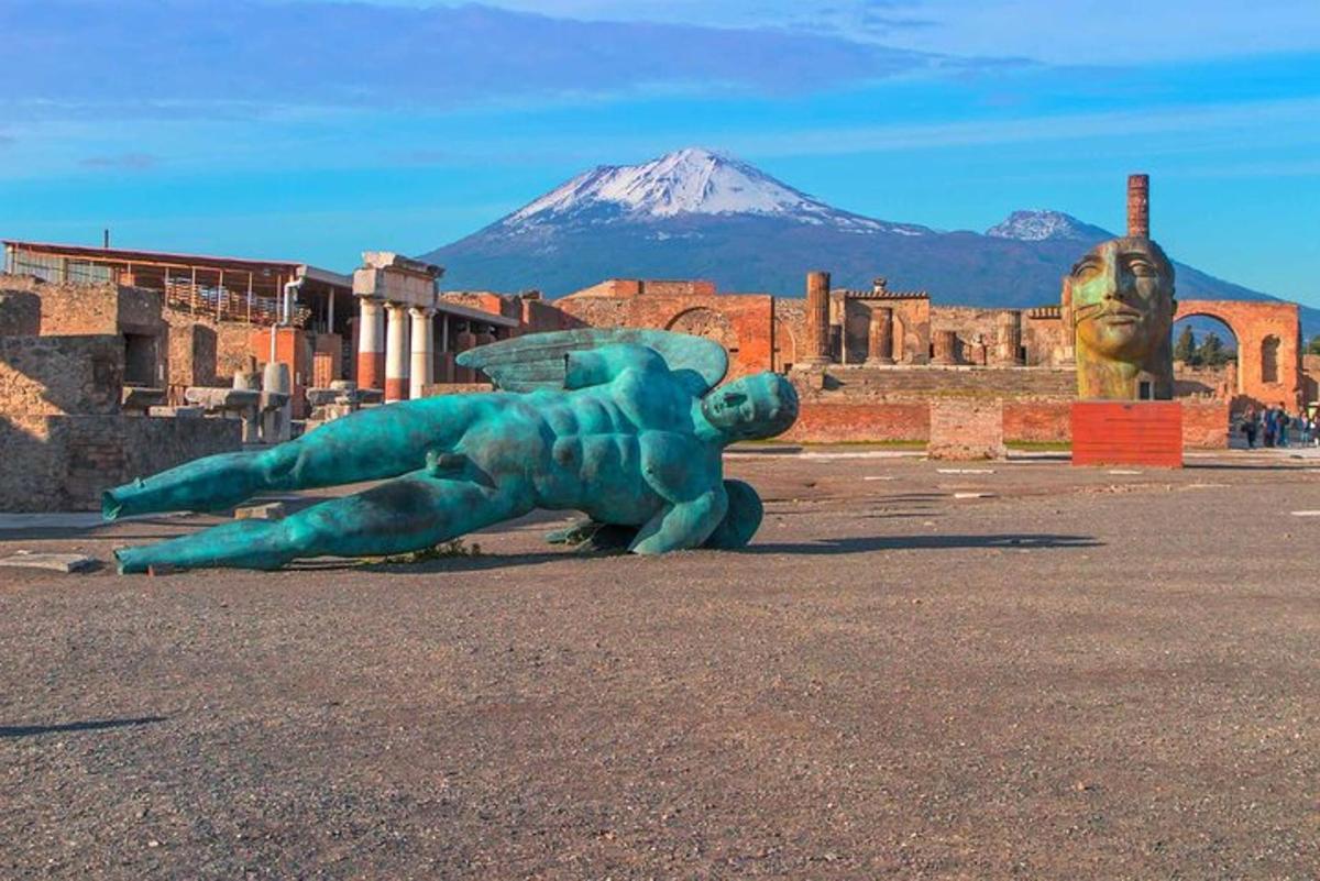 una statua di una lucertola seduta a terra con una montagna