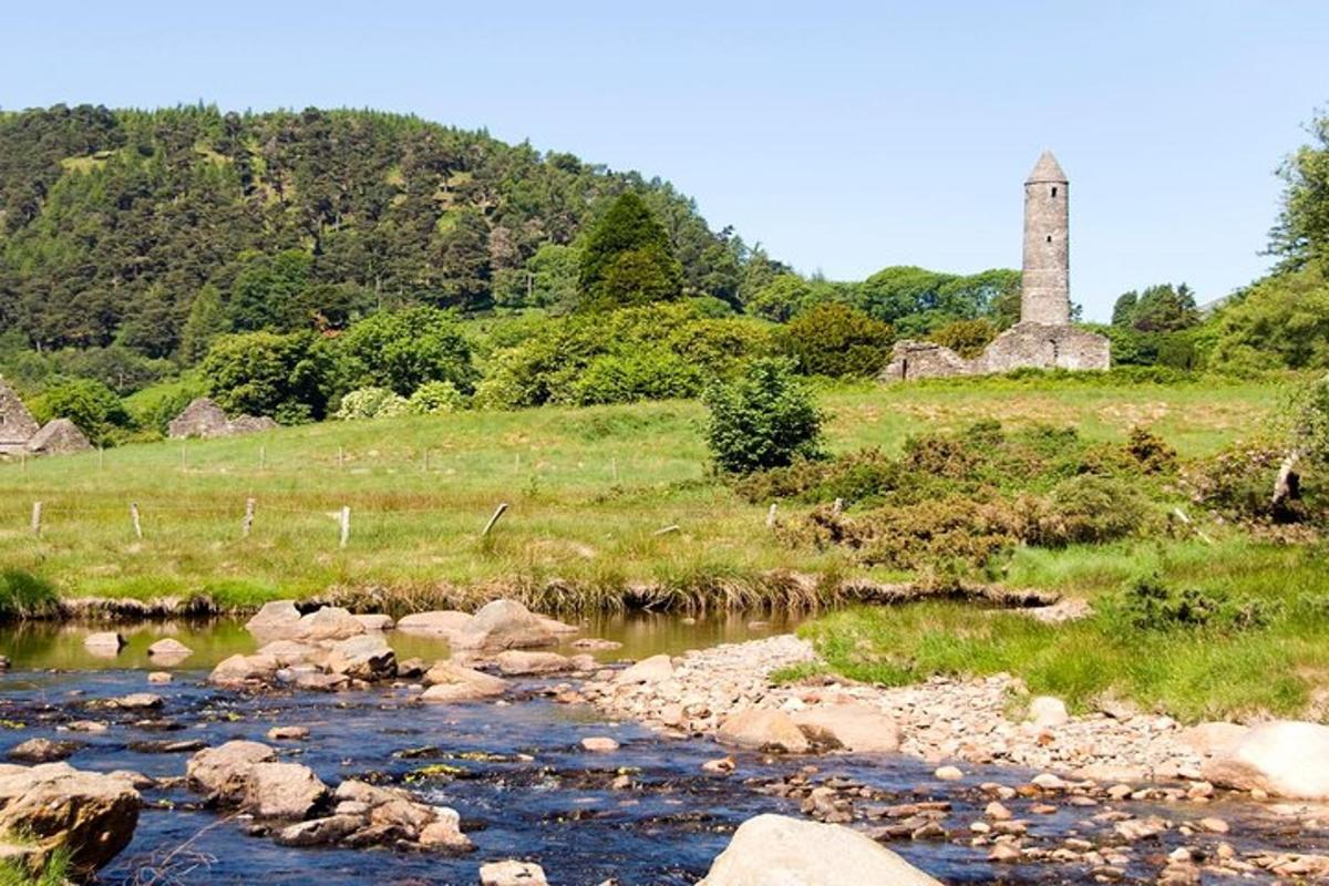 un fiume con una torre di pietra in un campo con una collina