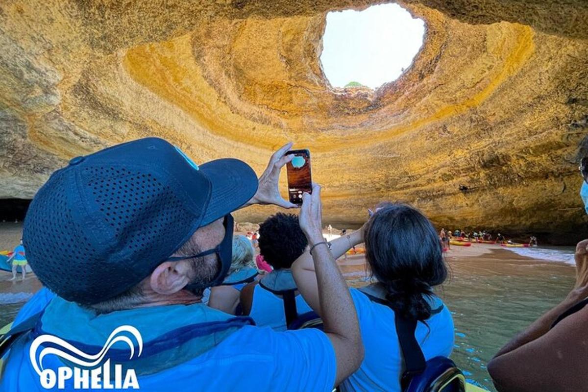 a man taking a picture of a group of people in a cave