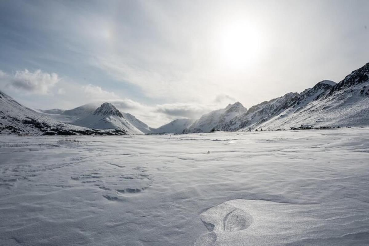 un lago ghiacciato con montagne innevate sullo sfondo