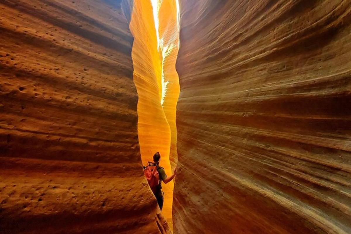 a man is standing in a slot canyon