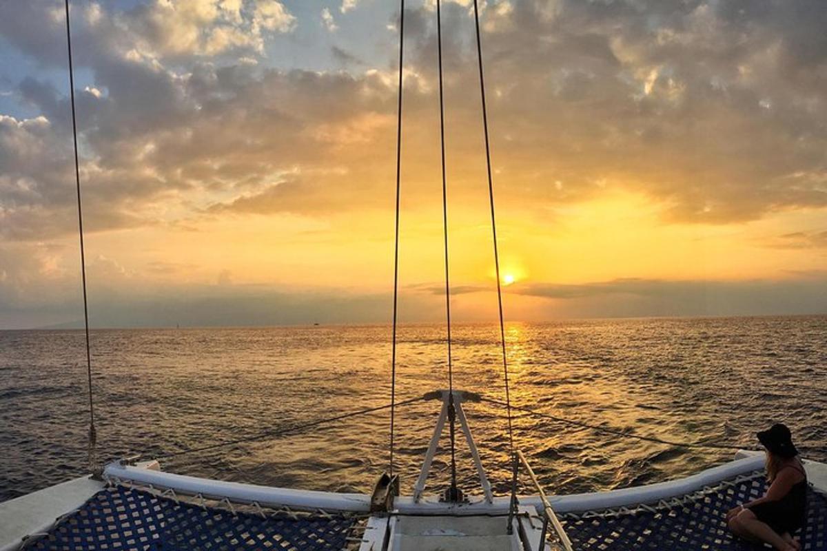 una persona sentada en la proa de un barco en el océano