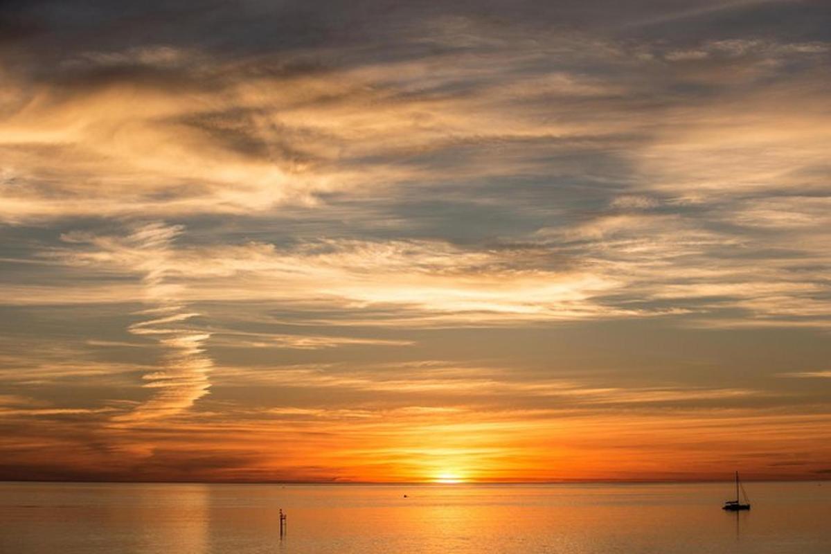 Západ slunce nad oceánem s lodí ve vodě