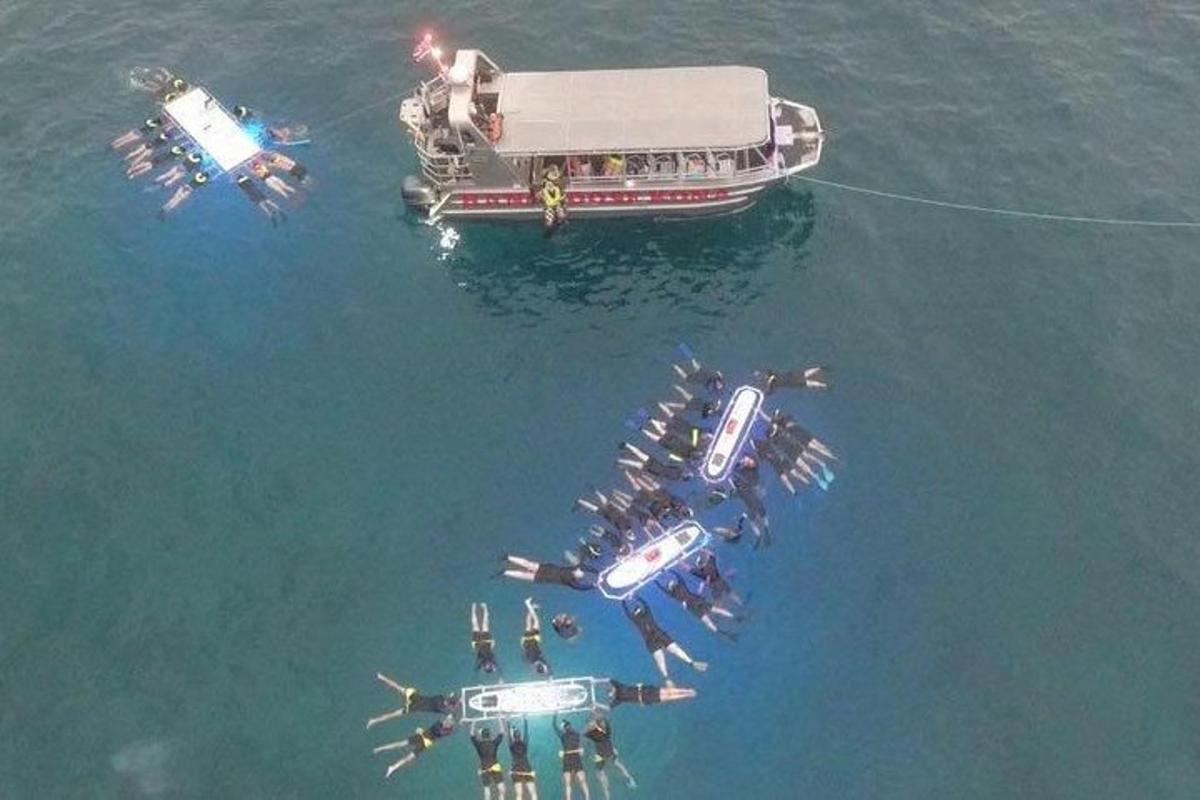 a group of people in the water next to a boat