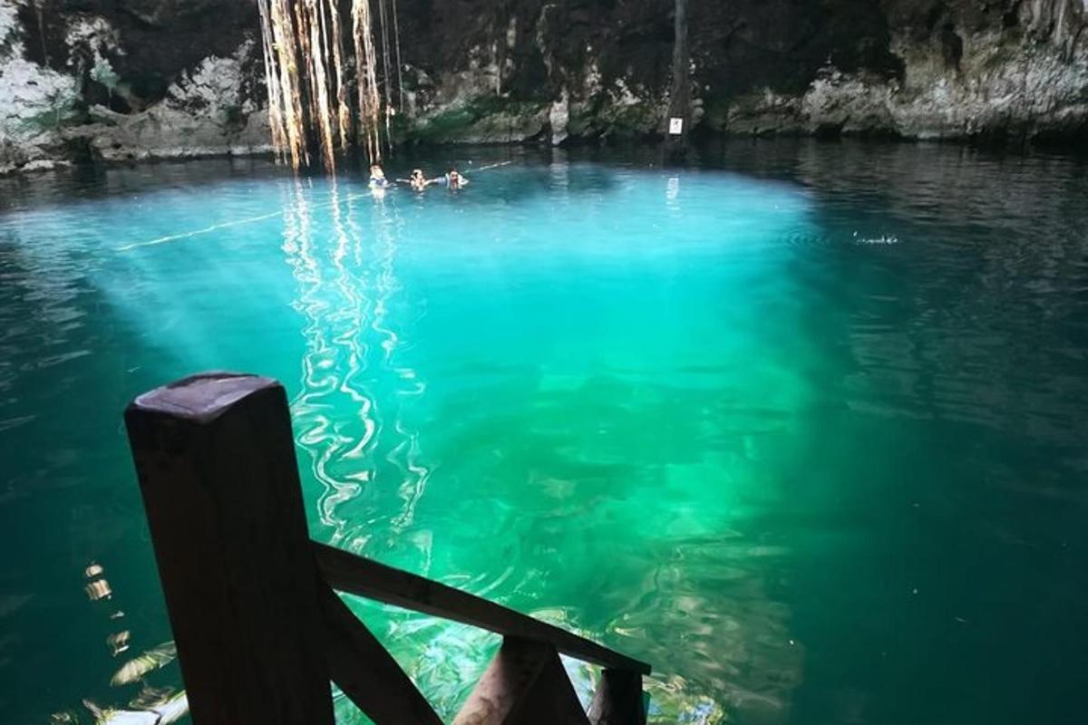 Una piscina de agua azul con gente nadando en ella.