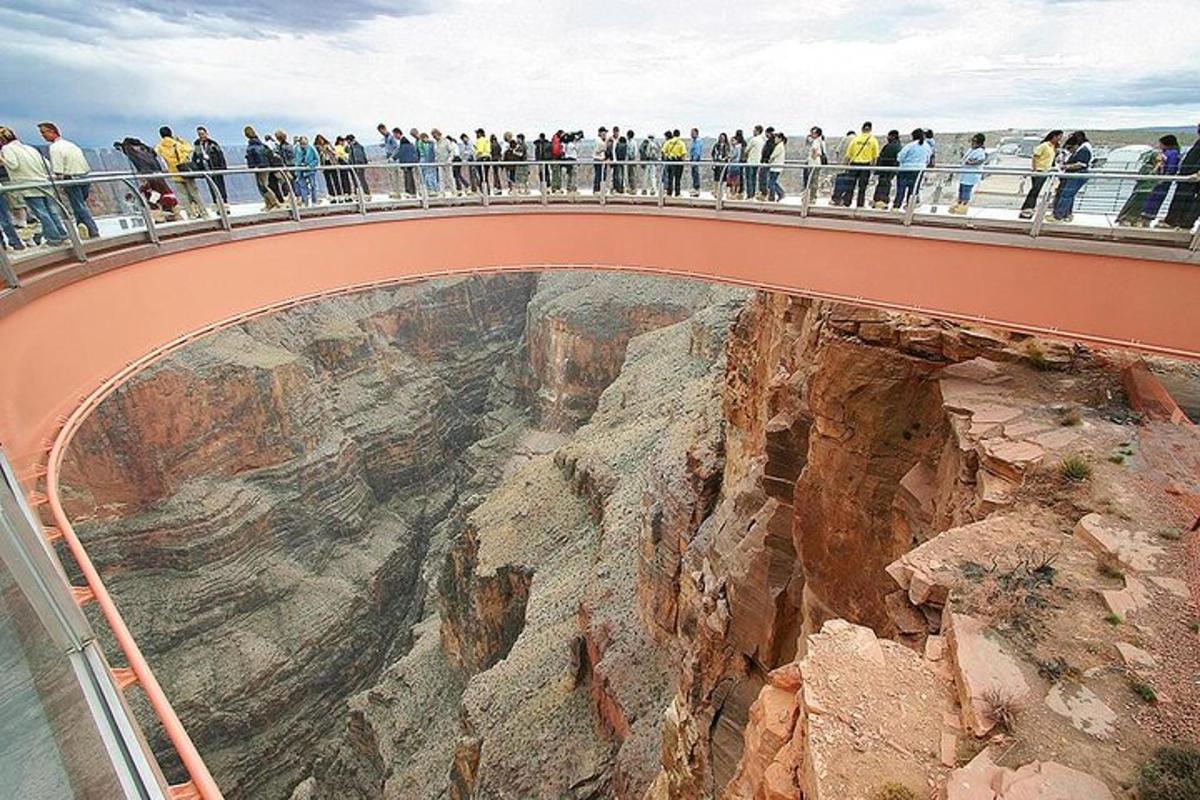 a group of people standing on a bridge over a canyon