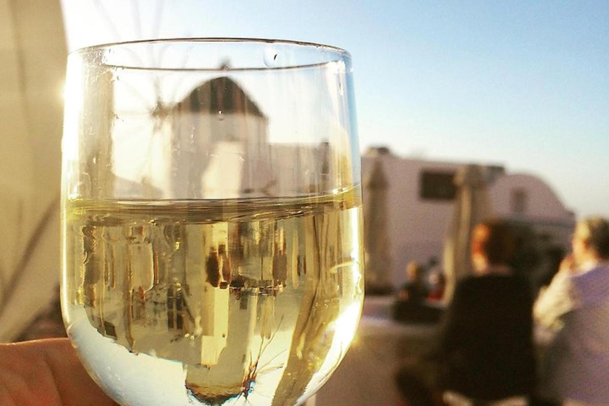 ein Glas Weißwein mit Menschen im Hintergrund