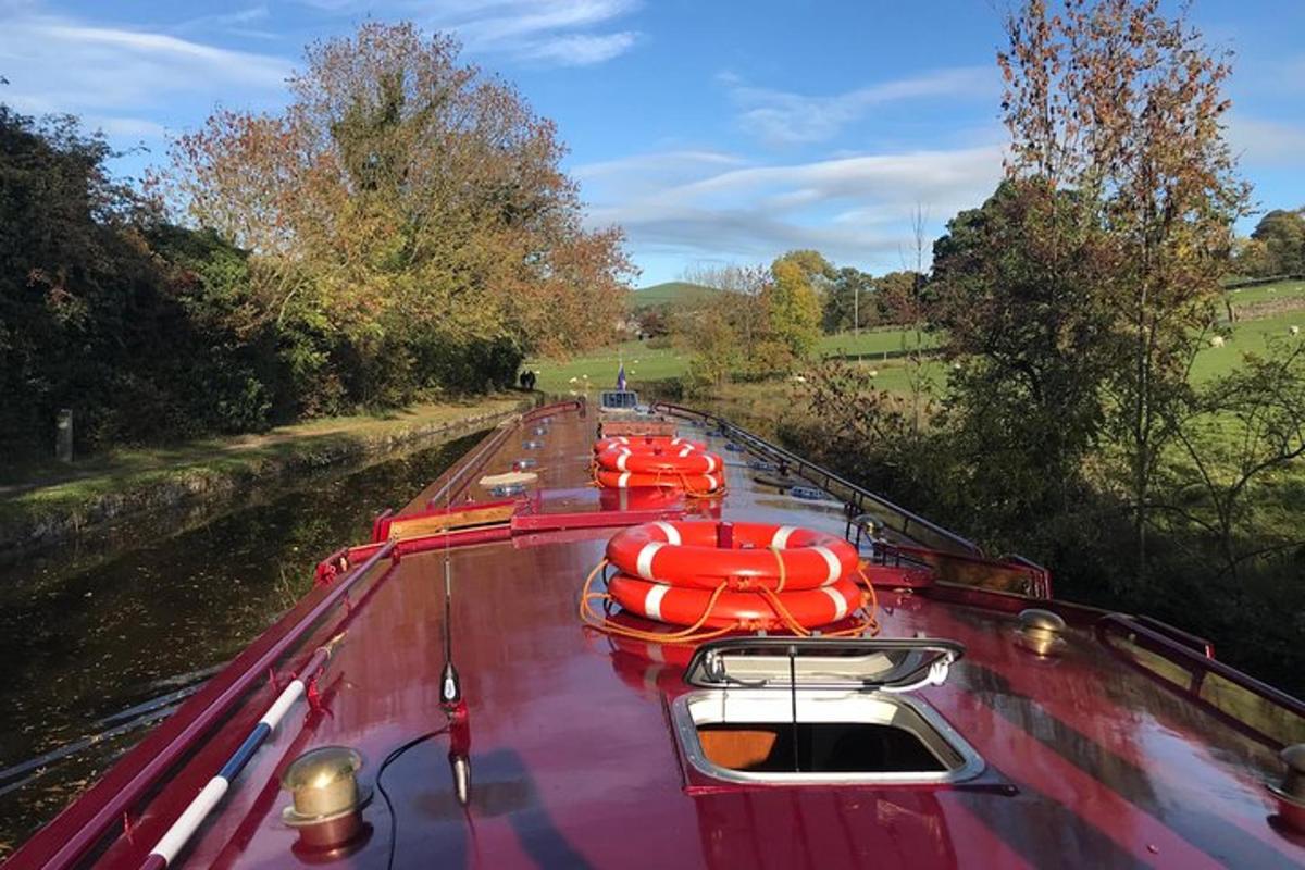 a boat with red rafts on the side of a river