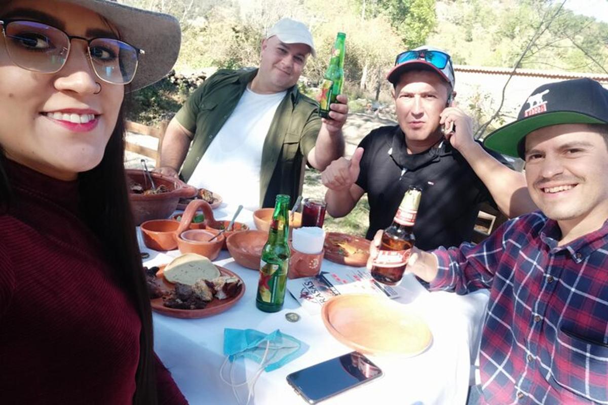un gruppo di persone in piedi attorno a un tavolo con del cibo