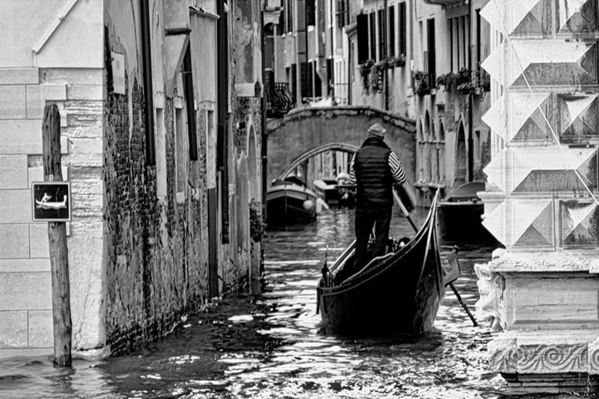 un uomo sta navigando in gondola in un canale