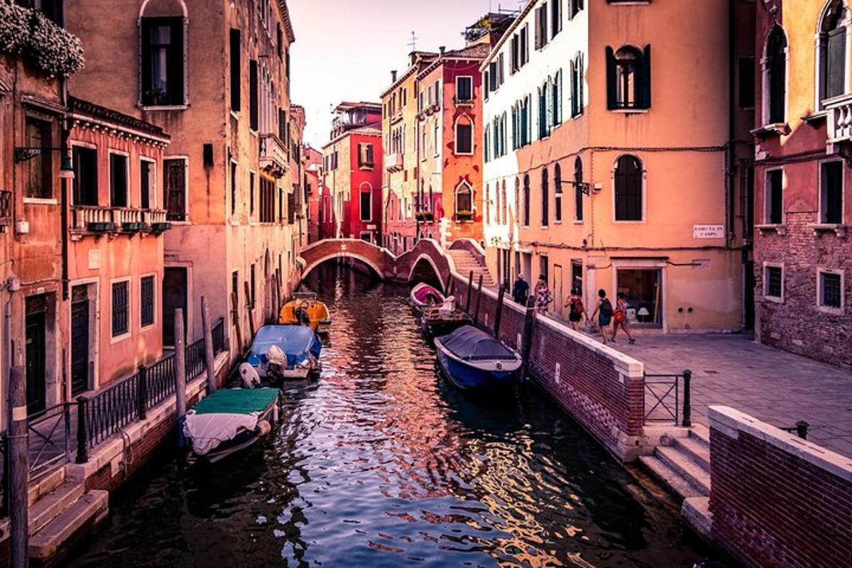 un gruppo di barche in un canale tra edifici