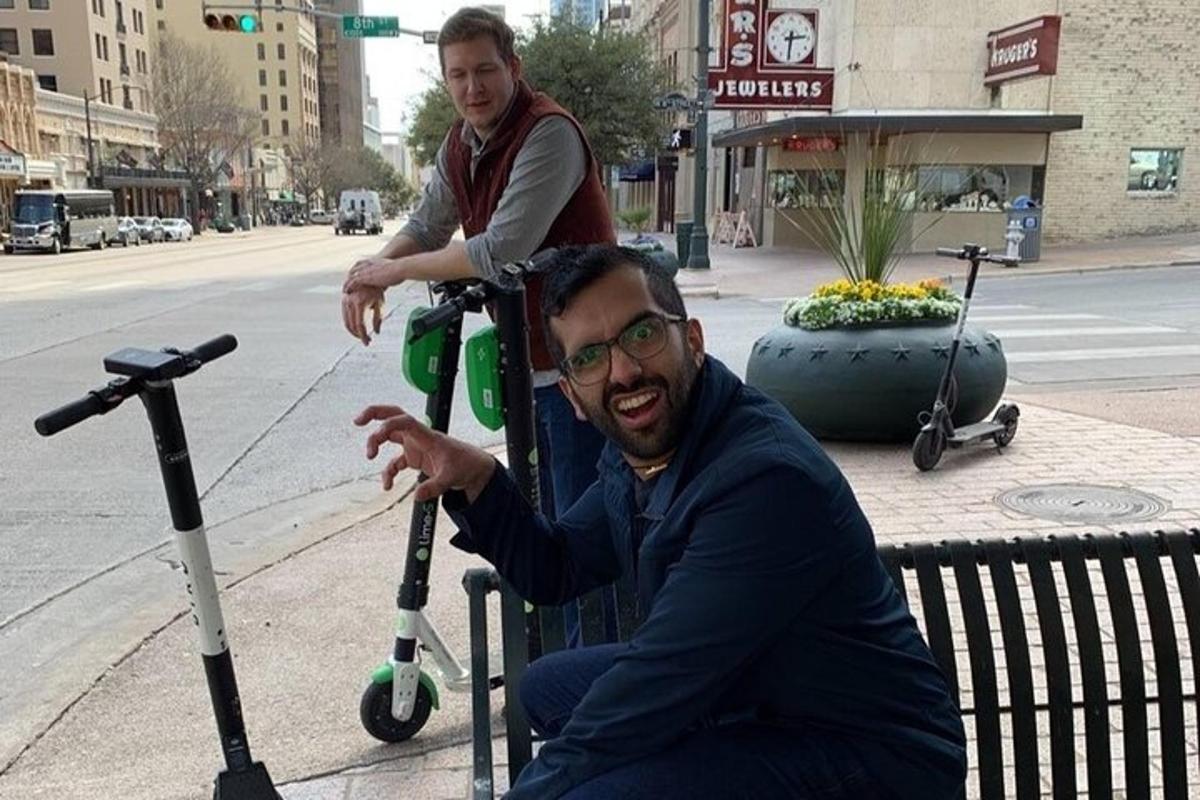 a man sitting on a bench next to two scooters