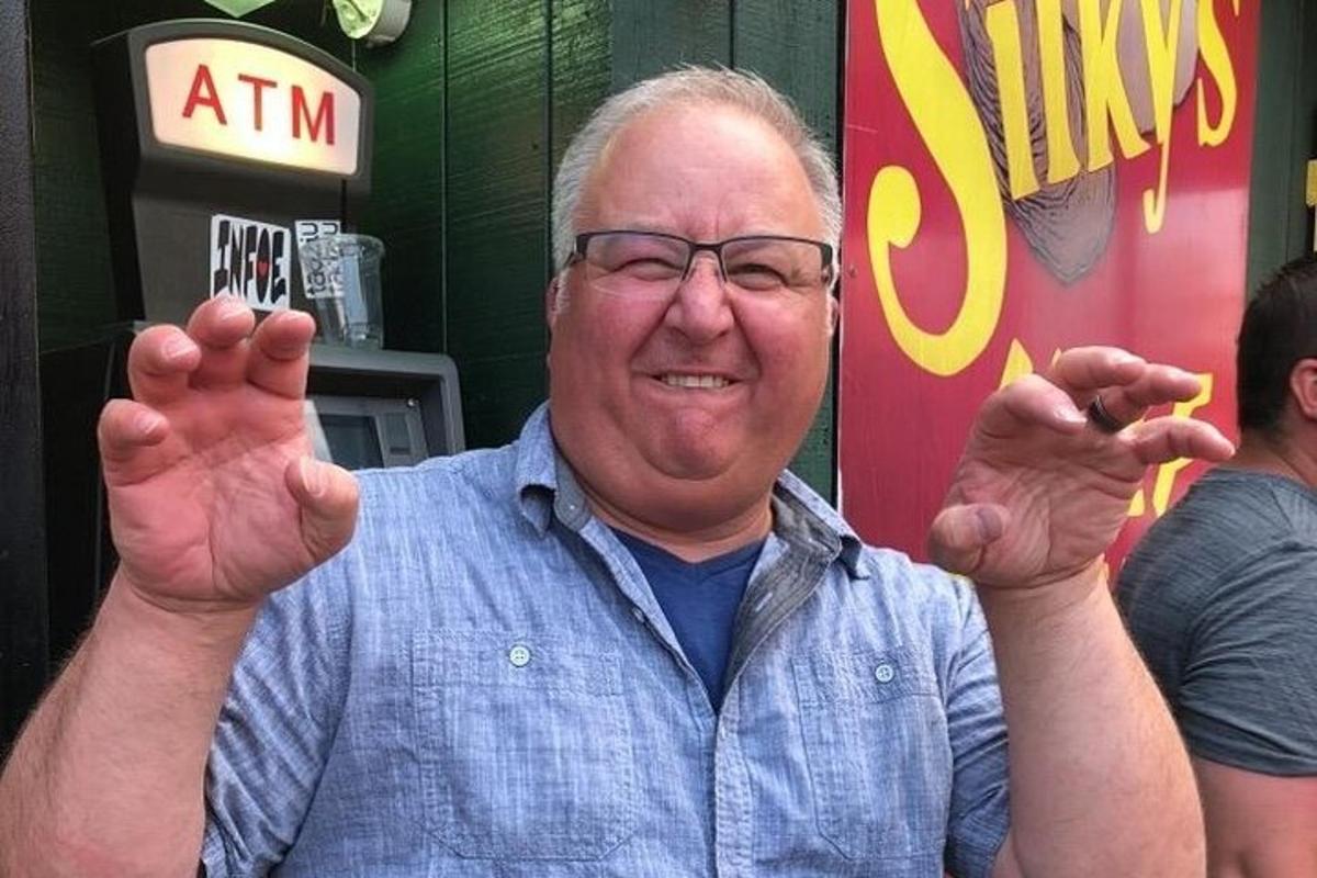 an older man is holding his hands in the air