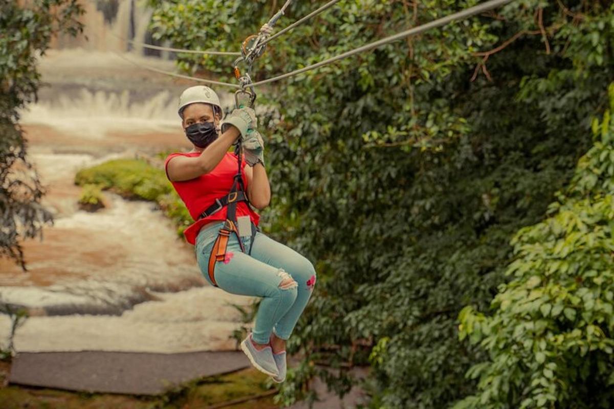 žena na zip line před vodopádem