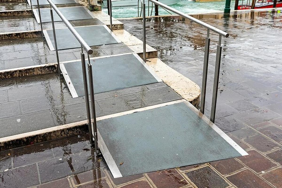 a row of steps in the water with a metal railing