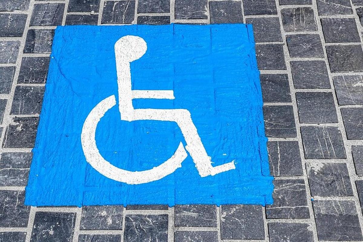 et blåt og hvidt handicapskilt på en gade