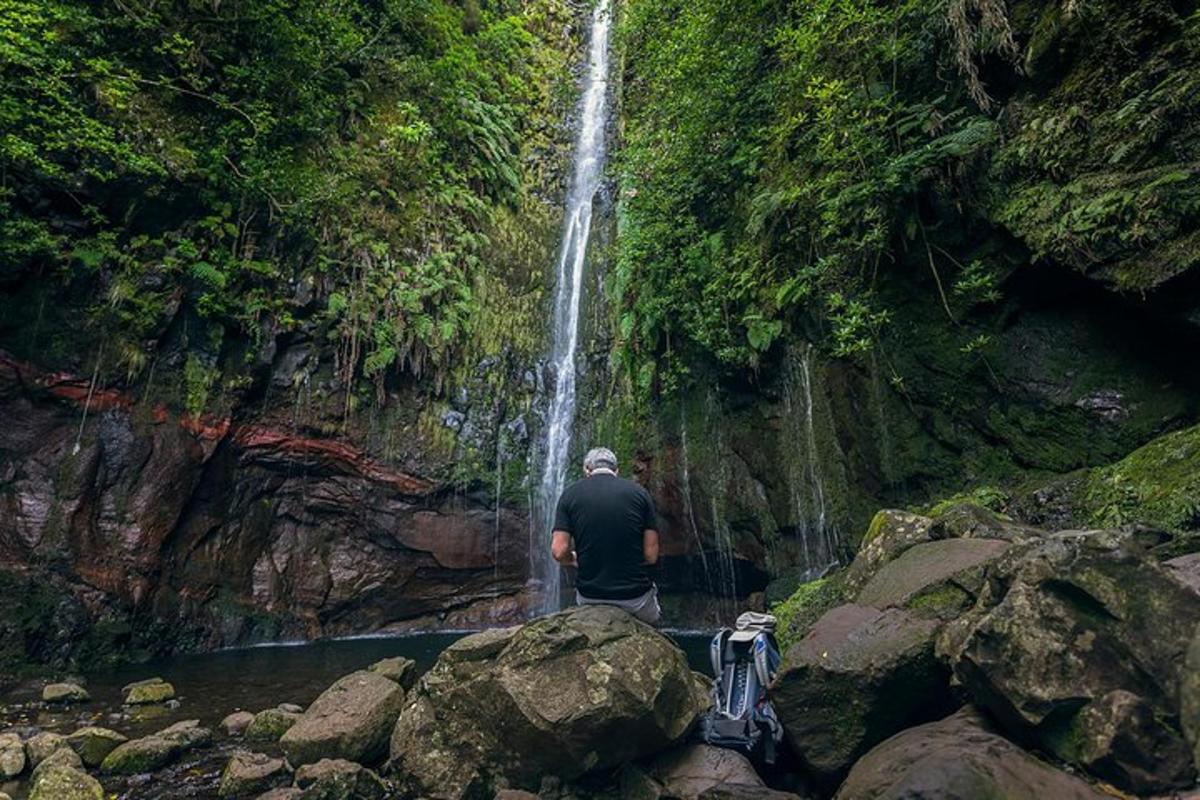 un hombre parado frente a una cascada