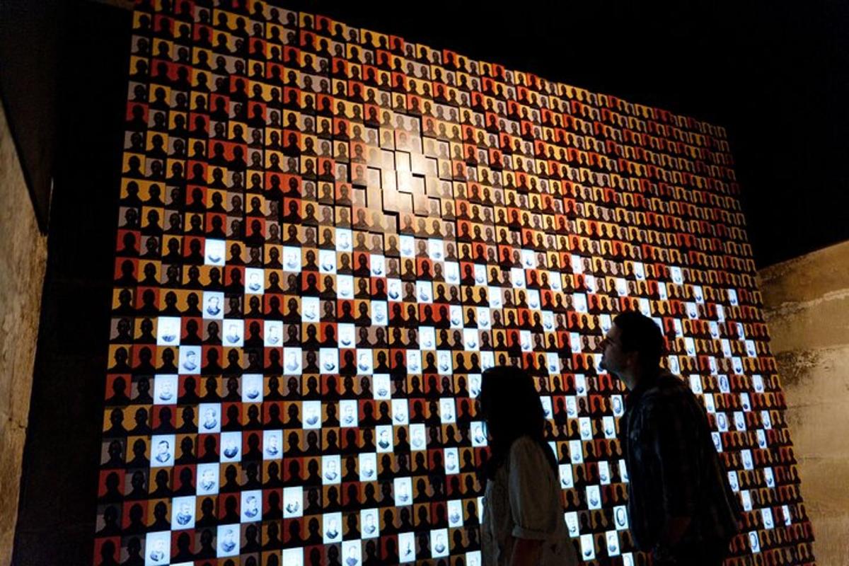 a man standing in front of a wall of wine bottles