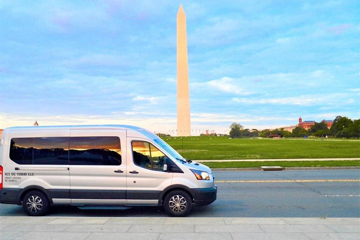 một chiếc xe tải màu trắng đậu trước tượng đài Washington