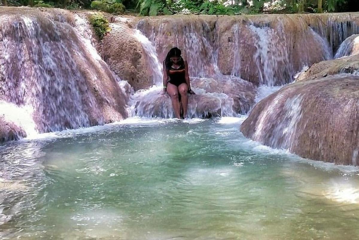 seorang wanita sedang berdiri di dalam air terjun