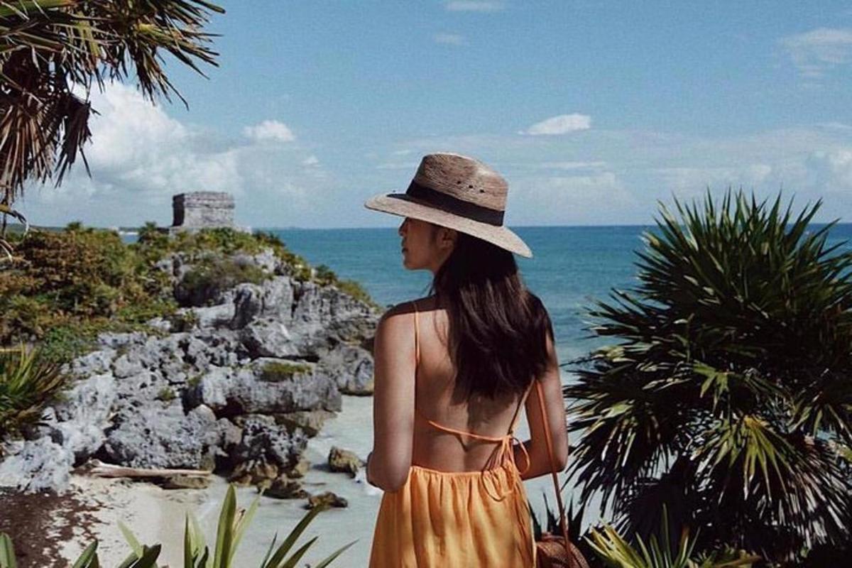 una donna con un cappello guarda l'oceano
